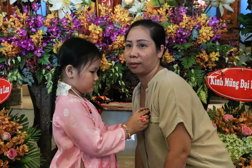 Con gái cẩn thận cài hoa lên ngực áo cho mẹ bày tỏ sự hiếu thảo và lòng thành của một người con. Con gái cẩn thận cài hoa lên ngực áo cho mẹ bày tỏ sự hiếu thảo và lòng thành của một người con.