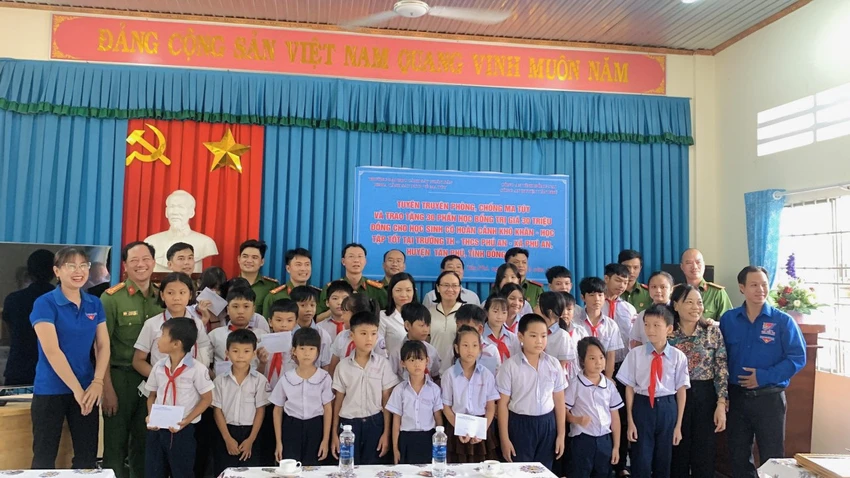 Các cán bộ công an trao học bổng cho các em học sinh. Ảnh: CA Các cán bộ công an trao học bổng cho các em học sinh. Ảnh: CA