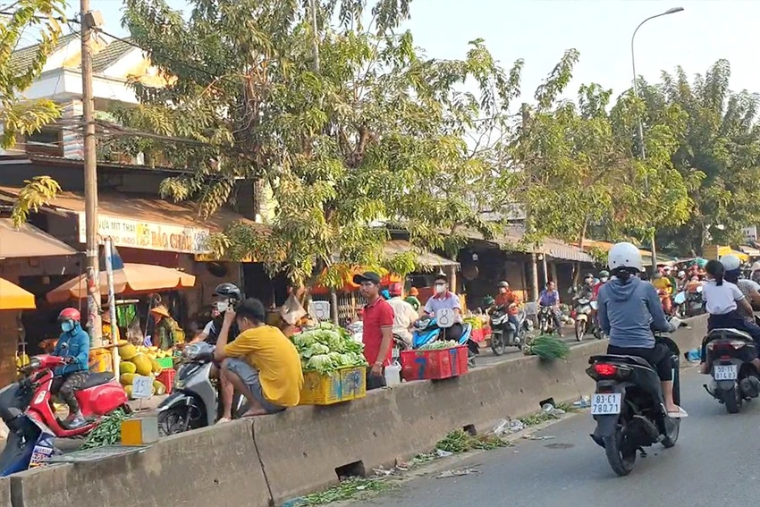 Người bán hàng rong quanh chợ đầu mối nông sản thực phẩm Hóc Môn bán hàng từ lòng lề đường, vỉa hè, dải phân cách... từ sáng tới tối. Ảnh: TÂN - YÊN Người bán hàng rong quanh chợ đầu mối nông sản thực phẩm Hóc Môn bán hàng từ lòng lề đường, vỉa hè, dải phân cách... từ sáng tới tối. Ảnh: TÂN - YÊN