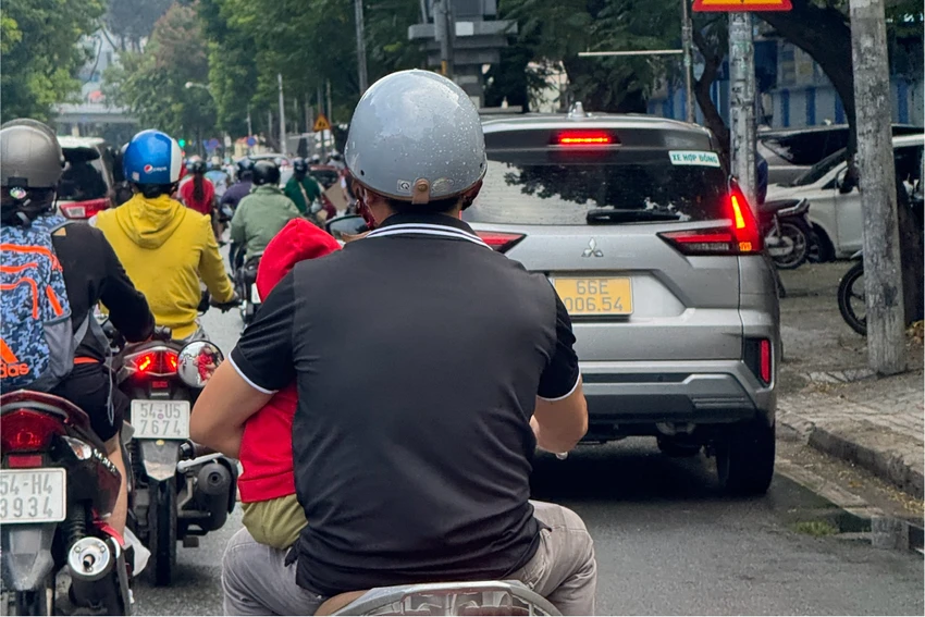Vừa chạy xe vừa bế con.jpeg