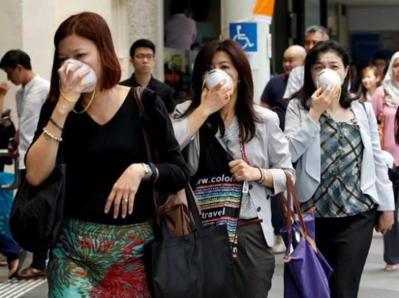 Người dân Singapore mang khẩu trang chống bụi sáng 26-8 vì ảnh hưởng cháy rừng ở Indonesia. 