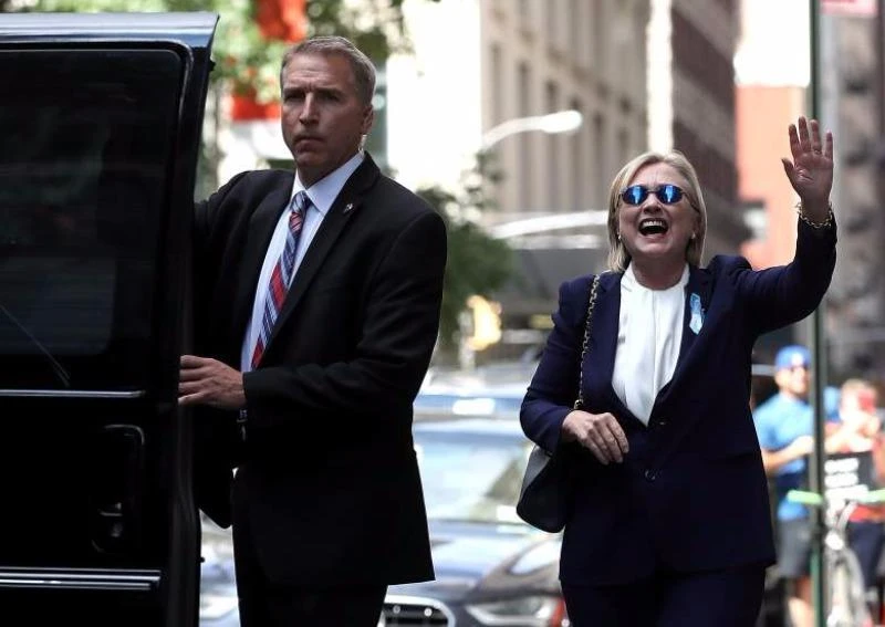 Bà Clinton cười và vẫy tay với báo chí khi rời khỏi nhà con gái ngày 11-9. 