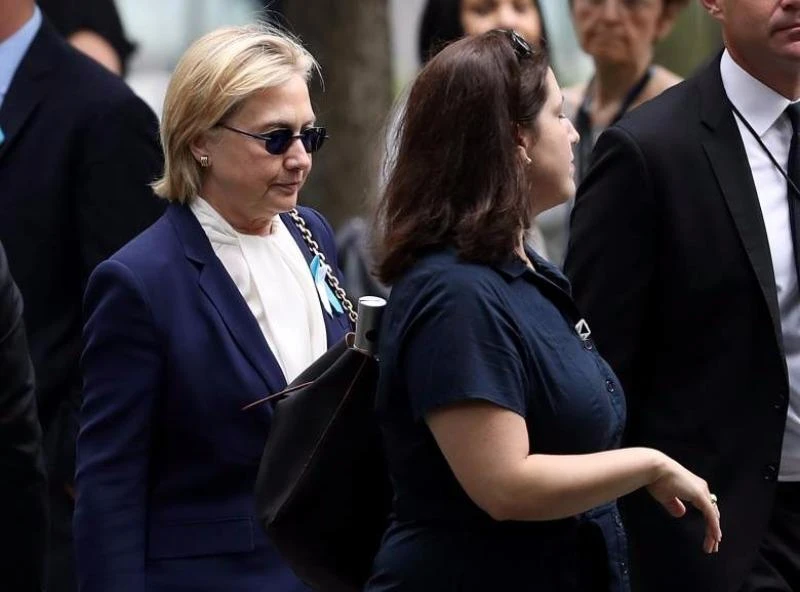 Bà Clinton được hộ tống ra xe sau khi bị trượt ngã tại lễ tưởng niệm sự kiện 11-9. 