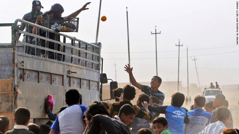 Quân Iraq phát trái cây cho người dân làng al-Khuwayn, ngoại ô phía nam Mosul sau khi chiếm lại làng này từ IS ngày 23-10. 