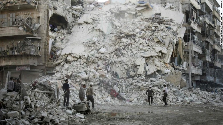 Nhân viên cứu hộ White Helmets trước đống đổ nát do không kích ở Aleppo ngày 17-11. 
