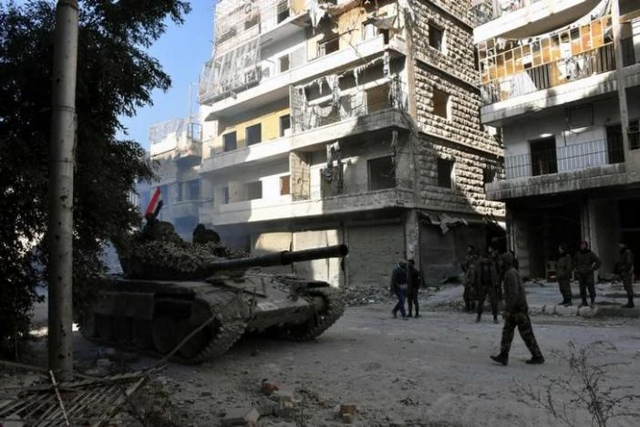 Lính và xe tăng chính phủ Syria ở Aleppo ngày 8-12. Ảnh: REUTERS 