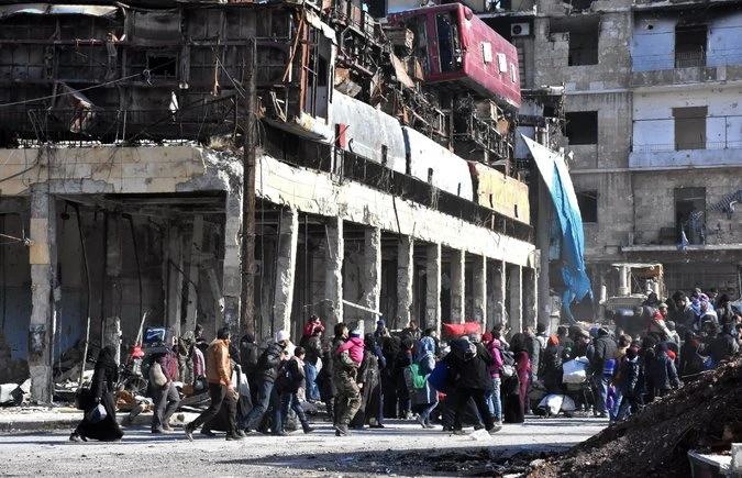 Người dân trở về nhà ở quận Bab al-Hadid thuộc đông Aleppo, nơi quân chính phủ đã chiếm lại từ phe nổi dậy. Ảnh: GETTY IMAGES 