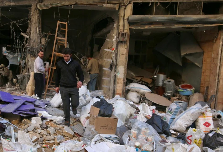 Người dân thu nhặt tài sản sau khi cửa hàng của mình ở quận al-Shaar (Aleppo) bị không kích trúng ngày 7-11. 