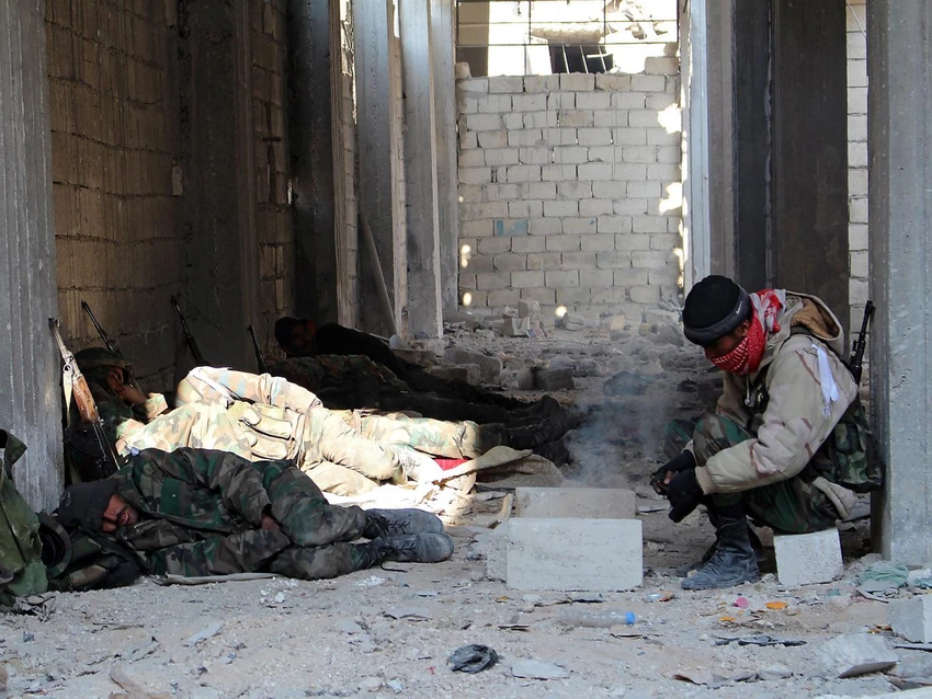 Quân chính phủ Syria nghỉ ngơi sau một cuộc giao tranh chiếm lại quận Sheil Saeed (đông Aleppo) ngày 12-12. Ảnh: EPA