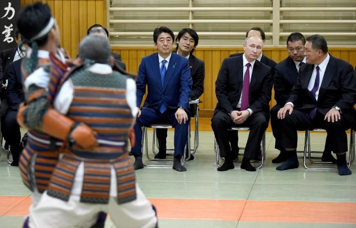 Tổng thống Putin (ngồi giữa), Thủ tướng Abe (trái), và Phó Chủ tịch Liên đoàn Judo Nhật Yasuhiro Yamashita (phải) xem biểu diễn judo tại Viện Judo Kodokan ở Tokyo (Nhật) ngày 16-12. Ông Putin vốn là một võ sĩ judo. Ảnh: RETERS