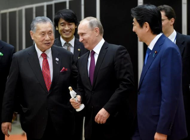 Tổng thống Putin (giữa) được tặng tượng người sáng lập môn võ Judo Jigoro Kano tại Viện Judo Kodokan ở Tokyo (Nhật) ngày 16-12. Ảnh: REUTERS 