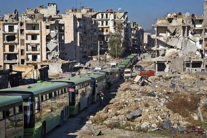 Xe buýt chở dân và phe nổi dậy rời khỏi đông Aleppo ảnh 2 Hàng dài xe buýt chở người đi sơ tán khỏi Aleppo ngày 15-12. Ảnh: GETTY IMAGES