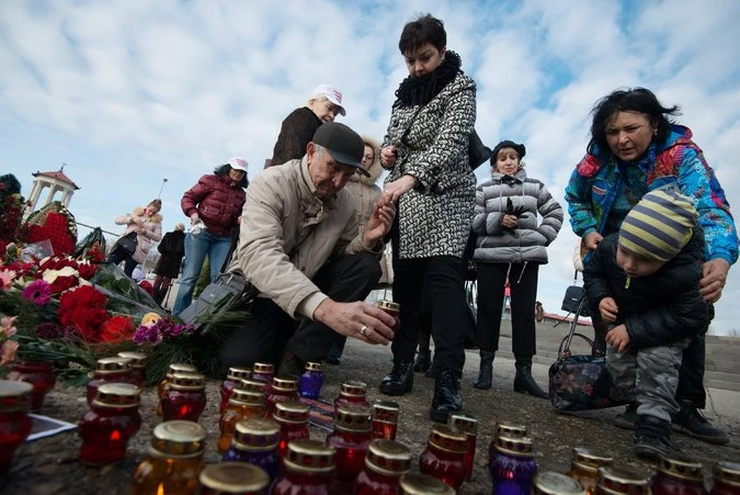 Người dân Sochi tưởng niệm nạn nhân trên bờ biển ngày 26-12. Ảnh: EPA 