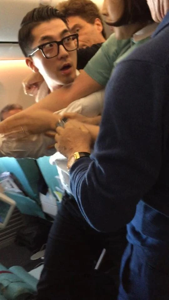 Hành khách (mang kính) quậy trên máy bay Korean Air bị ca sĩ Marx và các hành khách khác khống chế. Ảnh: TWITTER