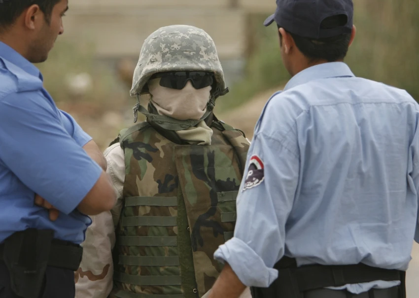 Thông dịch viên Iraq (giữa) làm việc cho lính Mỹ thường phải che kín mặt vì sợ trả thù. Ảnh: REUTERS