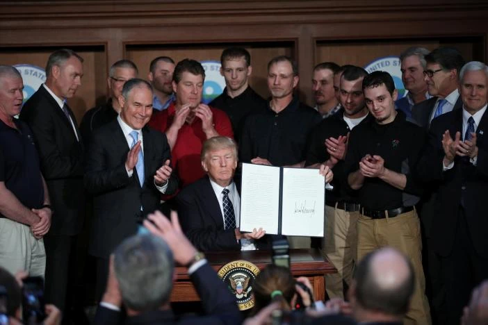 Tổng thống Mỹ Donald Trump giơ cao sắc lệnh Độc lập Năng lượng ông ký ngày 28-3 tại trụ sỡ Bộ Năng lượng ở thủ đô Washington (Mỹ). Ảnh: REUTERS