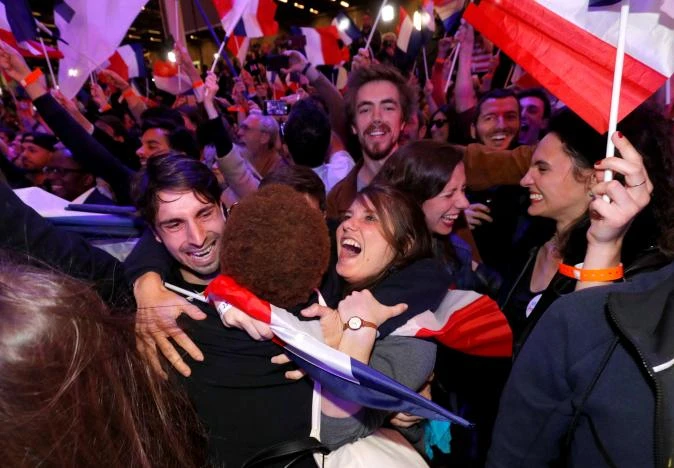 Người ủng hộ ông Marcon ăn mừng chiến thắng tại Paris, tối 23-4. Ảnh: REUTERS
