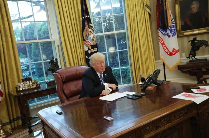 Tổng thống Trump đưa các bản sao bản đồ bầu cử (góc phải) cho các nhà báo Reuters tại phòng Bầu dục (Nhà Trắng) ngày 27-4. Ảnh: REUTERS