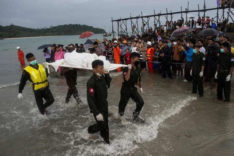 Thi thể nạn nhân vớt được trên biển Andaman được lực lượng cứu hộ đưa vào bãi biển San Hlan, trong lúc người dân Myanmar tập trung ngày 8-6 chờ tin về người thân. Ảnh: AFP