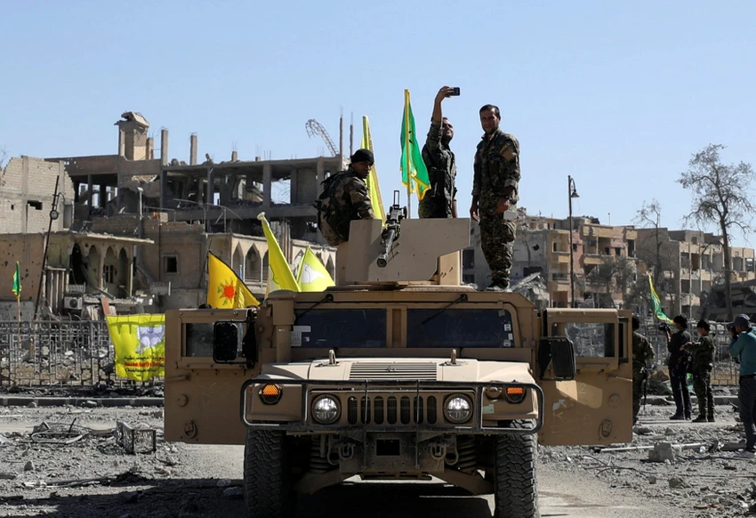 Một tay súng SDF chụp hình khi ngồi trên xe quân sự tại Raqqa ngày 17-10. Ảnh: SPUTNIK