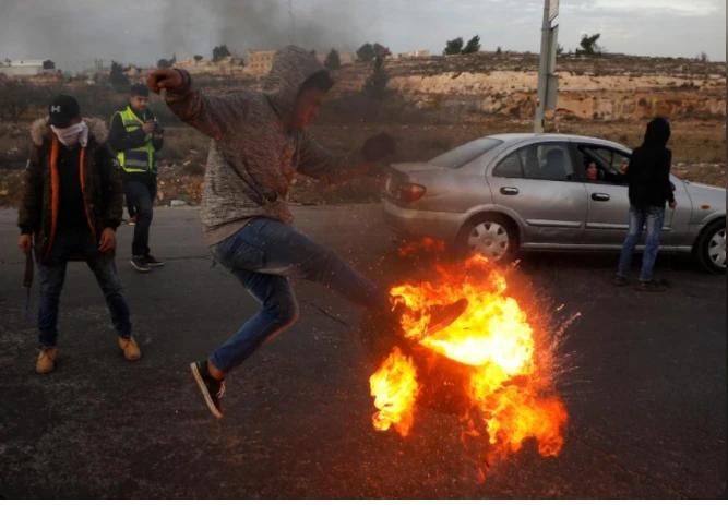 Người dân Palestine biểu tình gần một khu định cư Do thái Beit El gần TP Ramallah ở khu Bờ Tây ngày 10-12, phản đối quyết định công nhận Jerusalem là thủ đô của Israel của Tổng thống Mỹ Trump. Ảnh: REUTERS