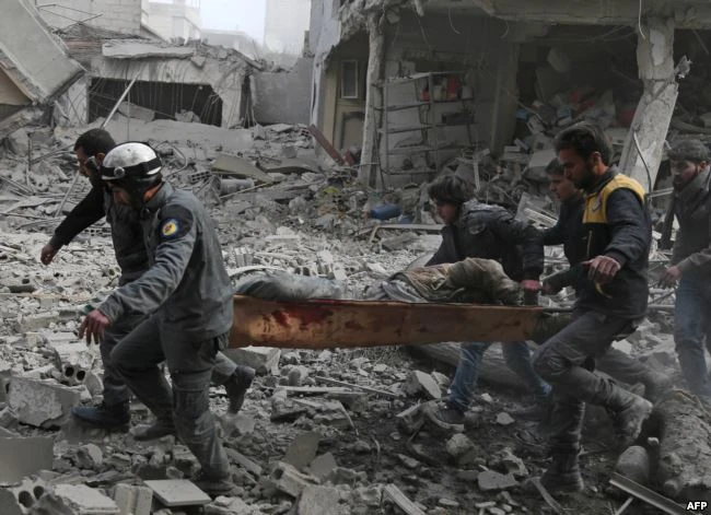 Lực lượng cứu hộ Syria sơ tán dân thường bị thương khỏi thị trấn Saqba ở Đông Ghouta, khu vực trúng không kích của quân chính phủ Syria ngày 20-2. Ảnh: AFP