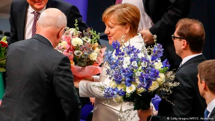 Bà Merkel nhận hoa chúc mừng chiến thắng sáng 14-3. Ảnh: GETTY IMMAGES