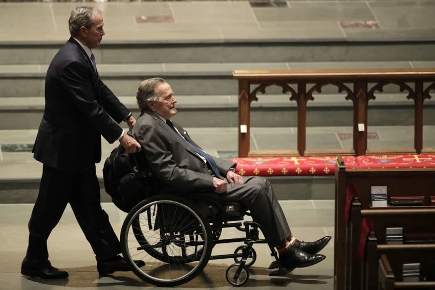 Cựu Tổng thống George H.W. Bush (Bush cha) ngồi xe lăn và được con trai là cựu Tổng thống George W. Bush đẩy đi trong lễ tang cựu Đệ nhất phu nhân Mỹ Barbara Bush ngày 21-4. Ảnh: AP
