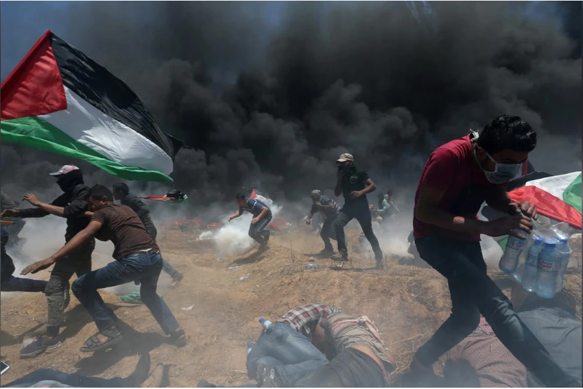 Người biểu tình Palestine oằn mình vì đạn khói Israel trong cuộc biểu tình tại biên giới Dải Gaza-Israel ngày 14-5, phản đối Mỹ khánh thành đại sứ quán ở Jerusalem. Ảnh: