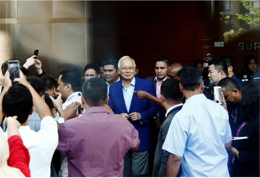 Cựu Thủ tướng Malaysia Najib Razak được hộ tống đến trình diện và chịu thẩm vấn tại Ủy ban Chống tham nhũng ở Putrajaya (Malaysia) sáng 22-5. Ảnh: REUTERS