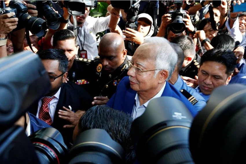 Cựu Thủ tướng Malaysia Najib Razak len lỏi trong hàng rào phóng viên khi đến trình diện và chịu thẩm vấn tại Ủy ban Chống tham nhũng ở Putrajaya (Malaysia) sáng 22-5. Ảnh: REUTERS