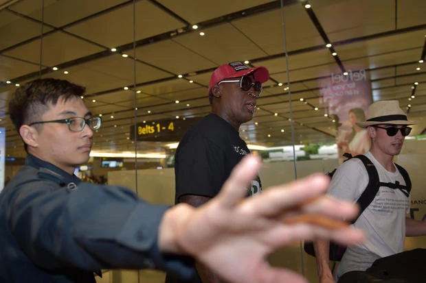 Cựu ngôi sao bóng rổ người Mỹ Dennis Rodman (mũ đỏ) đến sân bay Changi (Singapore) sáng sớm 12-6, chờ đón cuộc gặp thượng đỉnh Mỹ-Triều. Ảnh: GETTY IMAGES
