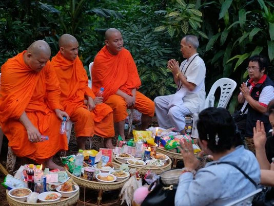 Lính Mỹ, thợ lặn Anh vào cuộc tìm kiếm đội bóng nhí Thái Lan ảnh 5 Các nhà sư và người thân cầu nguyện cho đội bóng nhí trước cửa hang động, ngày 28-6. Ảnh: GETTY IMAGES