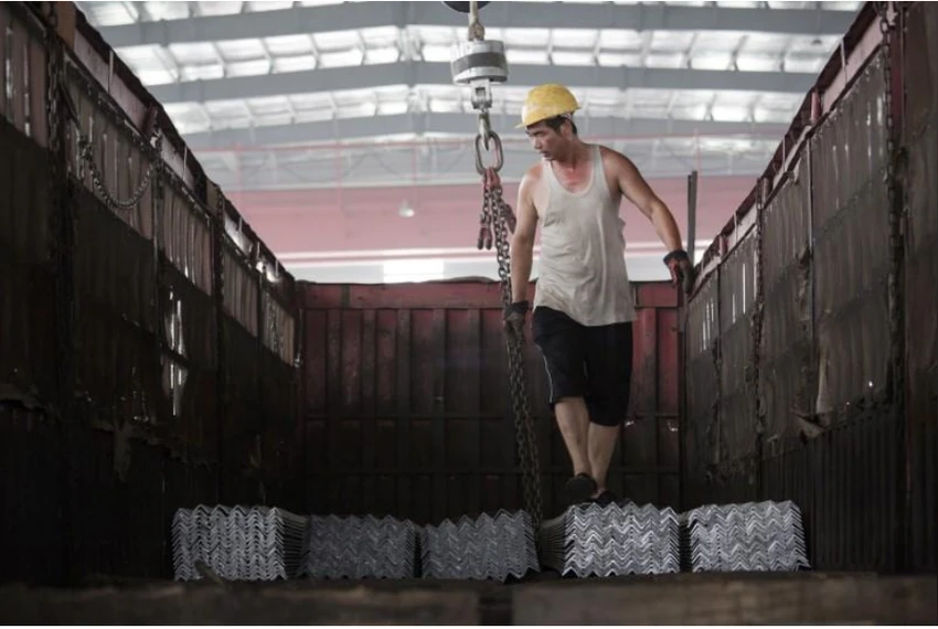 Công nhân sắp xếp thép thành phẩm lên một xe tải tại một nhà kho ở của tập đoàn thép Baifeng Iron and Steel Corporation ở tỉnh Hà Bắc (Trung Quốc). Ảnh: REUTERS