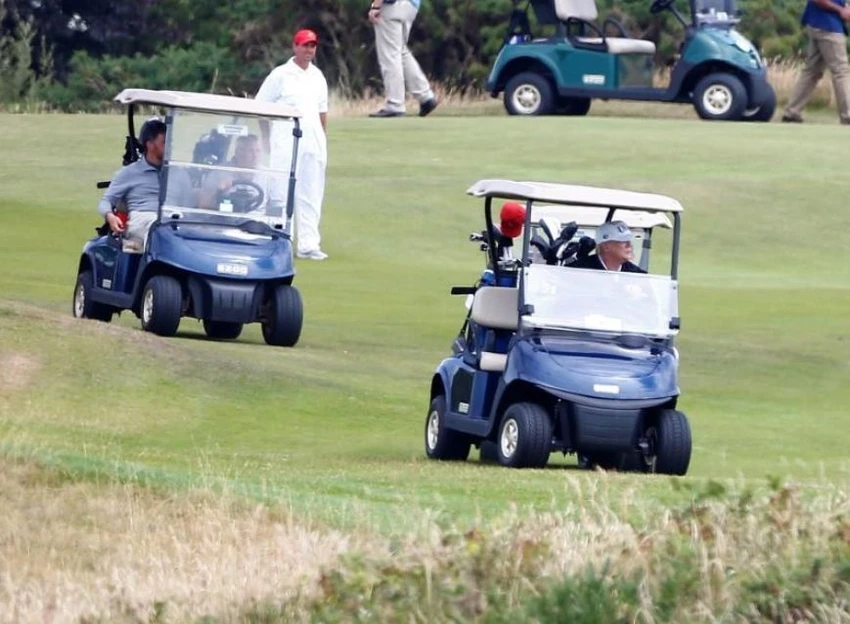 Tổng thống Mỹ Donald Trump lái xe (xe đầu) quanh khu nghỉ dưỡng đánh golf của mình ở Turnberry (Scotland) ngày 14-7. Ảnh: REUTERS