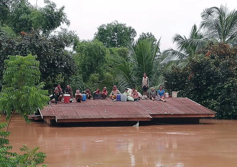 Người dân phải leo lên mái nhà tránh lụt. Ảnh: ABC LAOS NEWS