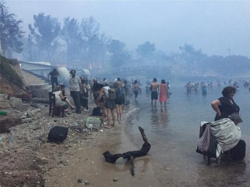 Người dân tràn xuống biển tránh lửa. Ảnh: GREEK REPORTER