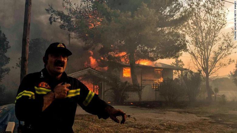 Nhân viên cứu hỏa vật lộn với lửa ngày 23-7. Ảnh: CNN