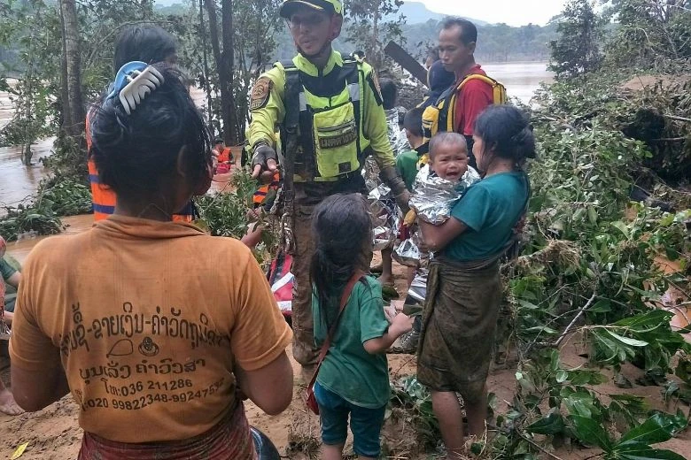 Nhân viên cứu hộ người Thái Lan giúp người dân sơ tán ở tỉnh Attapeu (Lào) ngày 26-7. Ảnh: AFP