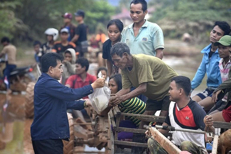Người dân nhận hàng cứu trợ tại huyện Sanamxai, tỉnh Attapeu (Lào) ngày 26-7. Ảnh: AFP