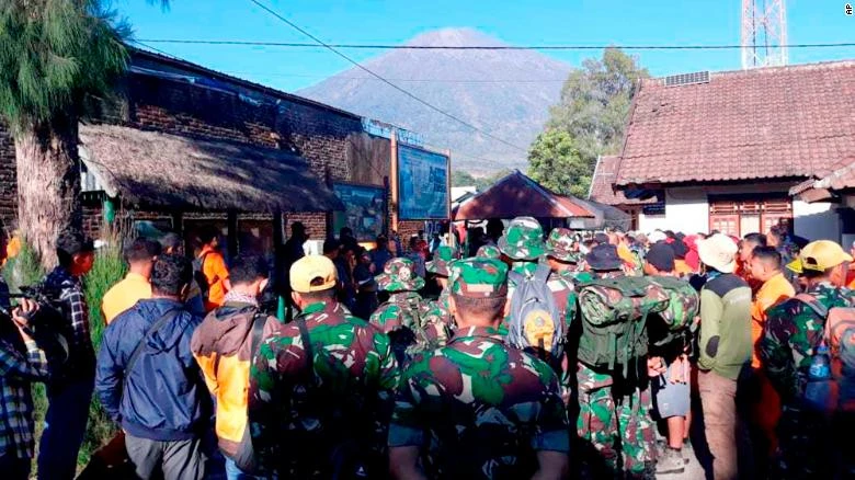 Binh sĩ Indonesia và nhân viên cứu hộ chuẩn bị vào cuộc sơ tán du khách ở núi Rinjani ở phía xa, tại đảo Lombok (Indonesia) ngày 30-7. Ảnh: CNN