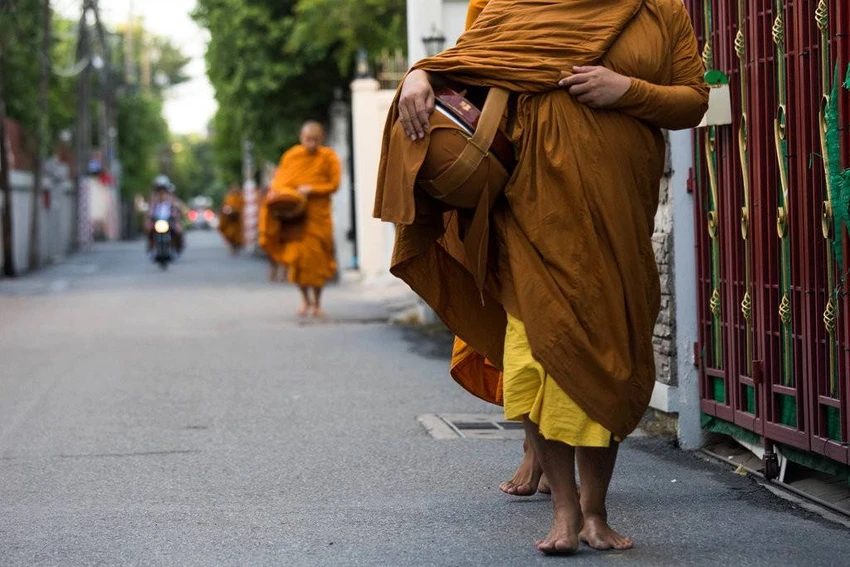Các nhà sư đang đi khất thực trên một con đường tại thủ đô Bangkok, Thái Lan. Ảnh: NEW YORK TIMES