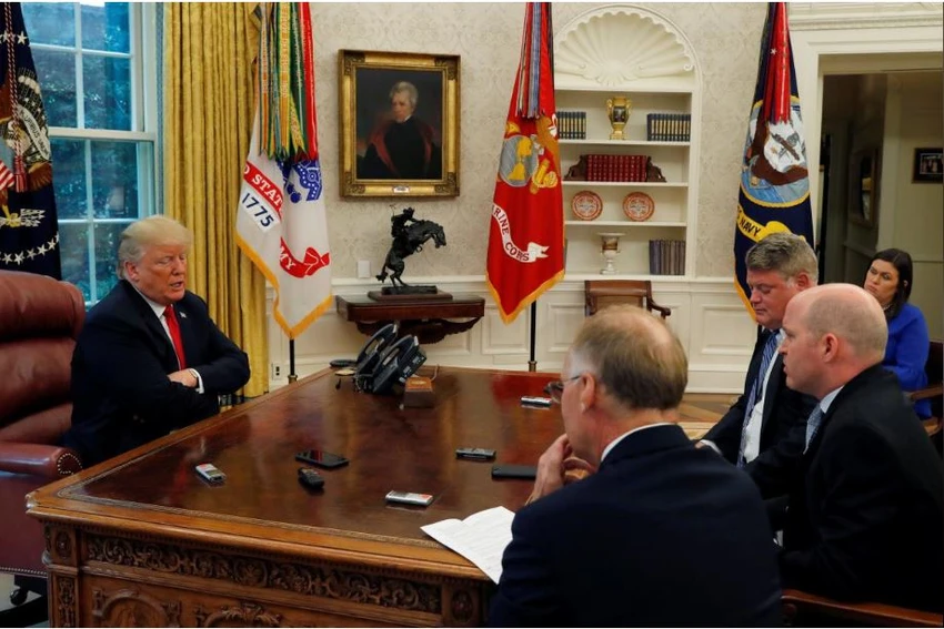 Tổng thống Mỹ Donald Trump (trái) trong buổi trả lời phỏng vấn các nhà báo Reuters tại Nhà Trắng ngày 20-8. Người phát ngôn Nhà Trắng Sarah Sanders (áo xanh) ngồi đằng sau. Ảnh: REUTERS
