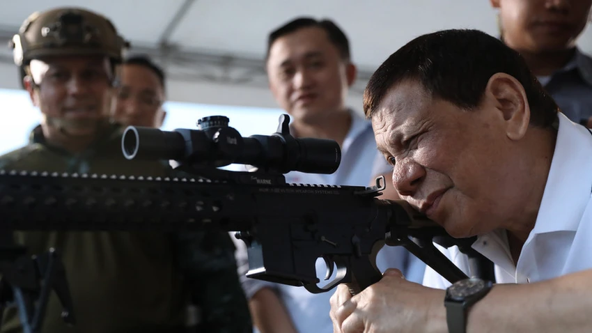 Ông Duterte bên một khẩu súng trường. Mỹ từ chối bán súng trường tấn công cho Philippines. Ảnh: AFP