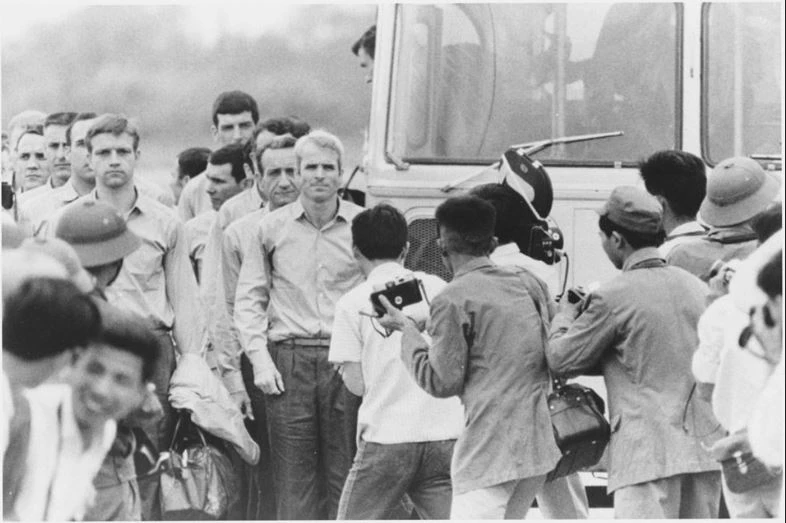 Cựu binh John McCain (giữa) và các cựu binh Mỹ được hộ tống đến sân bay ở Hà Nội để về Mỹ, ngày 14-3-1973. Ảnh: AP