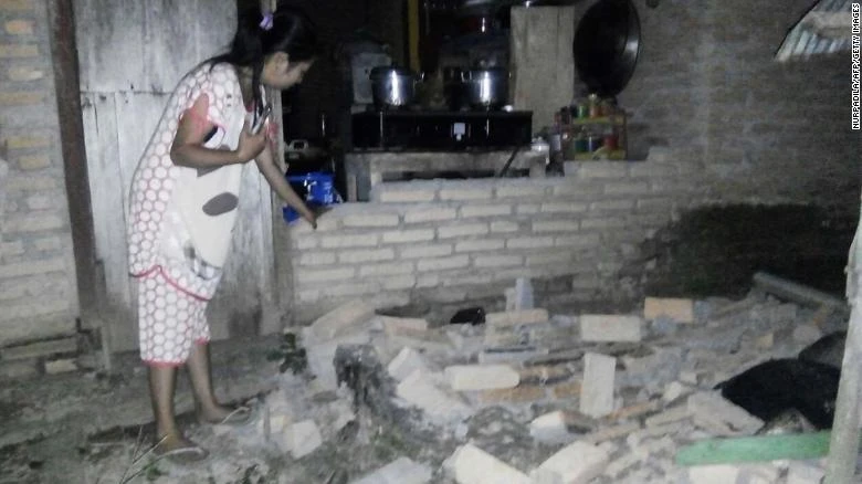 Người dân trong ngôi nhà đổ nát ở TP Mamuju, Tây Sulawesi (Indonesia) vì động đất. Ảnh: CNN