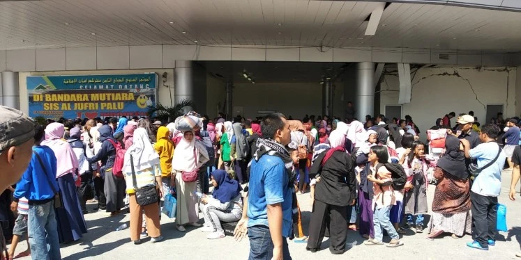 Indonesia: Cướp bóc tràn lan, người người kéo nhau rời Palu ảnh 1 Hàng trăm người, bao gồm cả người nước ngoài bao vây một chiếc máy bay Hercules của không quân Indonesia ngày 1-10, ba ngày sau thảm họa. Ảnh: JAKARTA POST