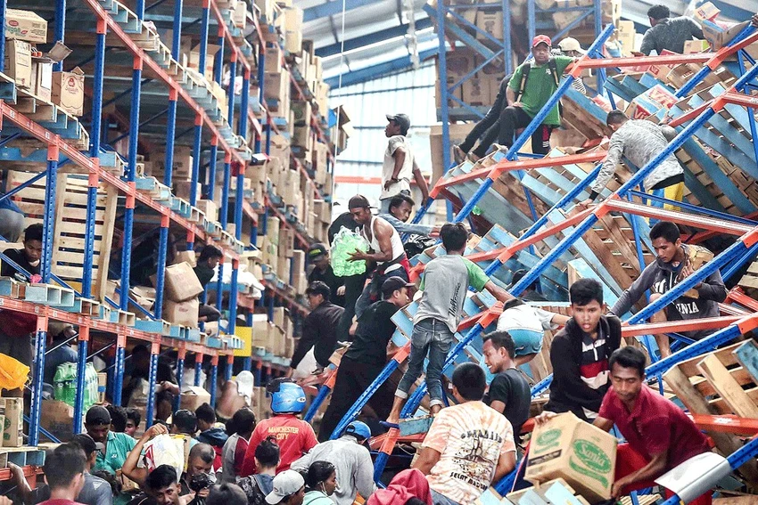 Người sống sót tràn vào một nhà kho tìm thức ăn ở Palu. Ảnh: ANTARA