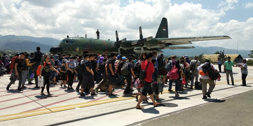 Người sống sót ở Palu kéo nhau lên một chiếc máy bay Hercules của không quân Indonesia ở sân bay Palu rời khỏi vùng thảm họa. Ảnh: JAKARTA POST