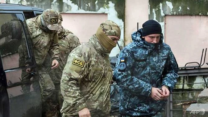 Nhân viên Cơ quan An ninh Liên bang Nga (FSB) hộ tống một thủy thủ Ukraine đến một tòa án ở TP Simferopol thuộc bán đảo Crimea ngày 26-11. Ảnh: AFP